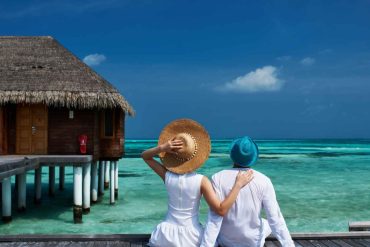 Couple watching the sunset at a luxury resort in the Maldives