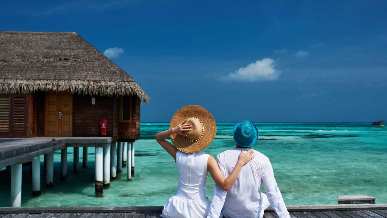 Couple watching the sunset at a luxury resort in the Maldives